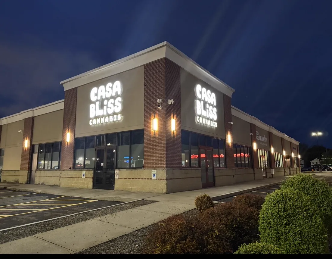 The Casa Bliss Cannabis storefront at night with the sign lit above the front doors